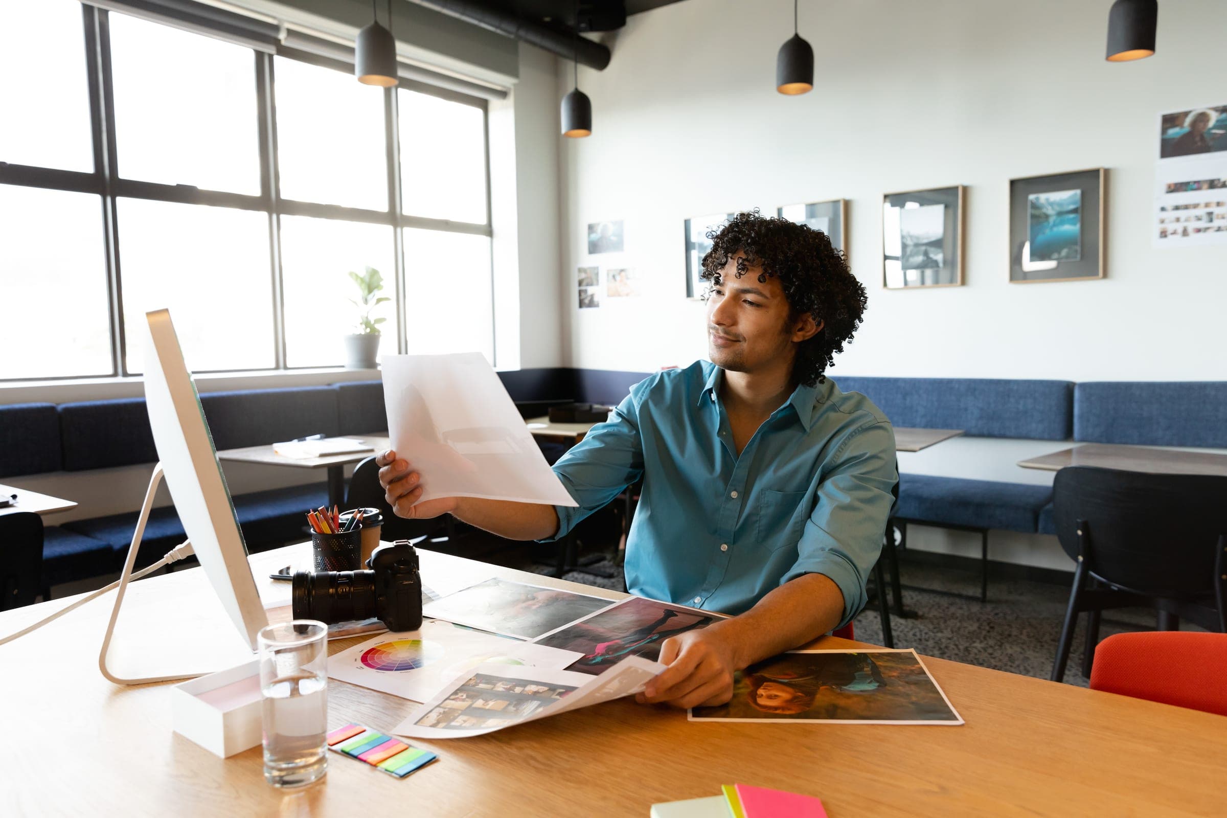 A maker reviewing printed work at a desk